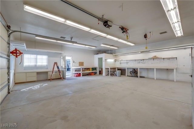 garage featuring a garage door opener and a workshop area