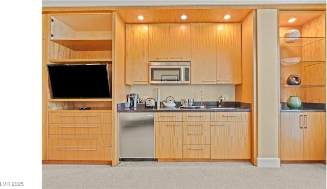 kitchen with fridge, sink, light colored carpet, and light brown cabinetry