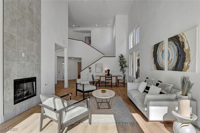 living room featuring a tile fireplace and light hardwood / wood-style floors