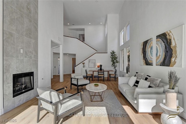 living room featuring a tiled fireplace and light hardwood / wood-style flooring