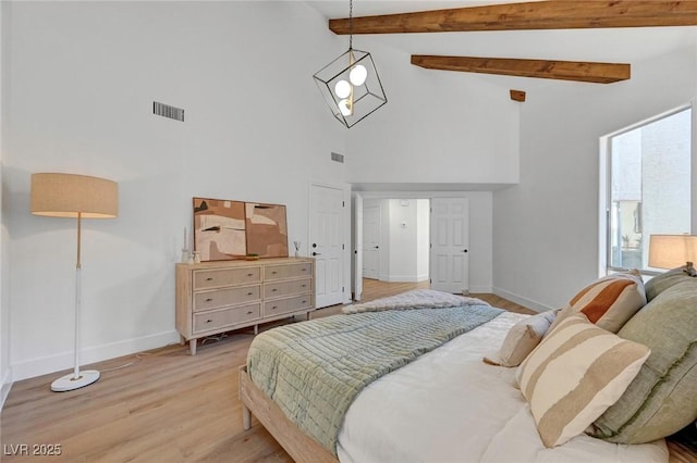 bedroom with high vaulted ceiling, beam ceiling, and light hardwood / wood-style floors