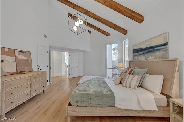 bedroom with high vaulted ceiling, beam ceiling, and light hardwood / wood-style floors