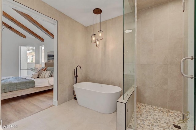 bathroom featuring shower with separate bathtub, tile walls, and vaulted ceiling with beams