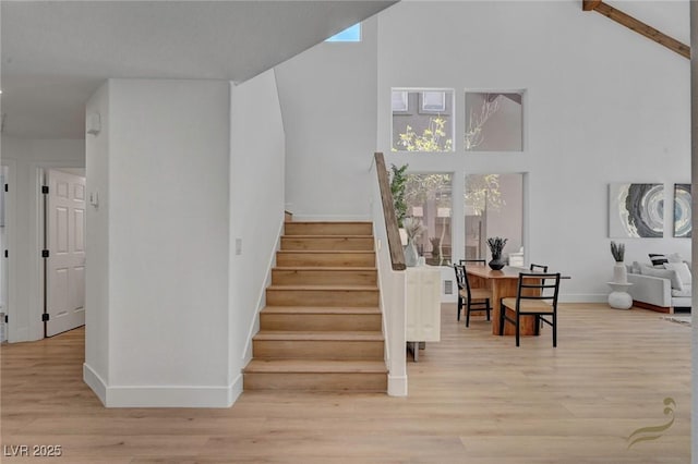 staircase featuring hardwood / wood-style flooring and a towering ceiling