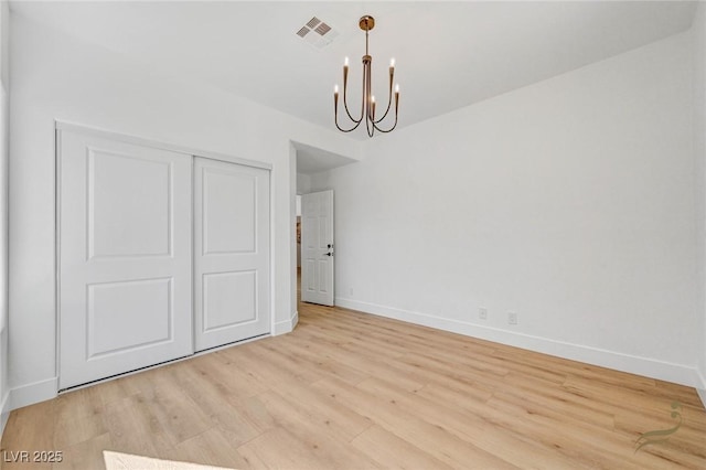 unfurnished dining area with an inviting chandelier and light hardwood / wood-style floors