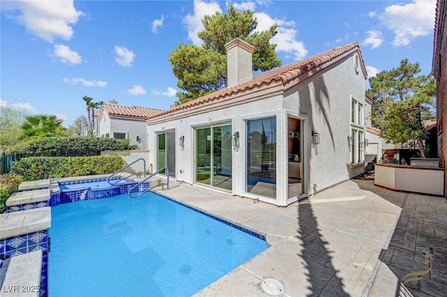 back of property with a pool with hot tub and a patio