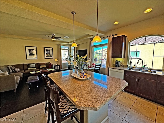 kitchen with sink, a kitchen breakfast bar, a center island, white dishwasher, and dark brown cabinets