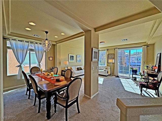 carpeted dining room featuring crown molding and a textured ceiling