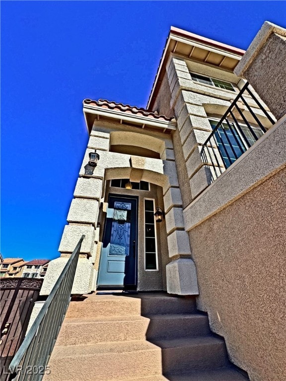 view of exterior entry with a balcony