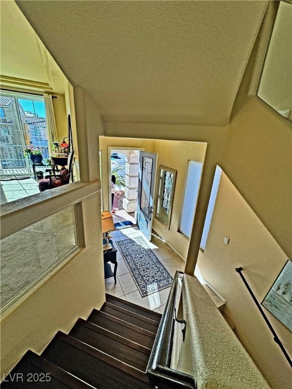 stairs with tile patterned flooring and a textured ceiling