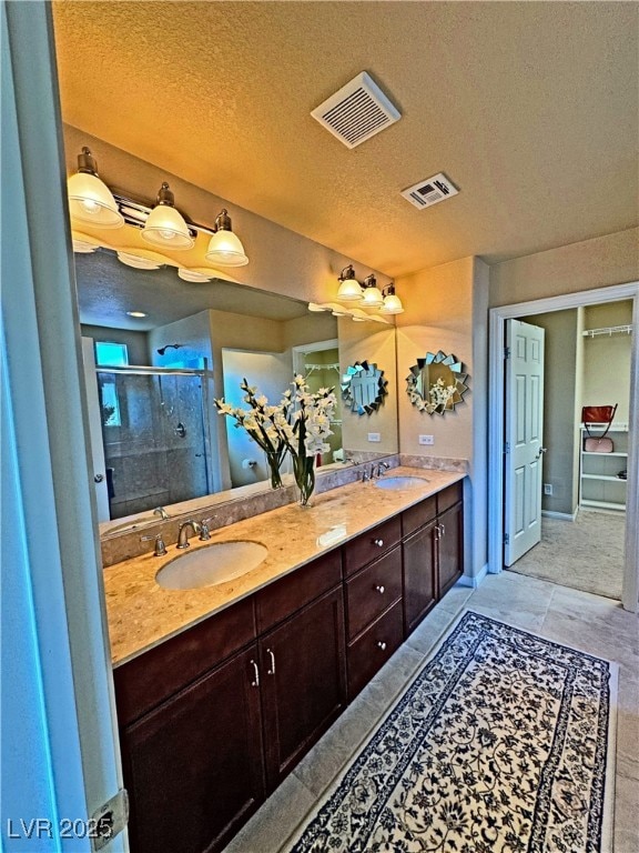 bathroom featuring vanity, a textured ceiling, and walk in shower