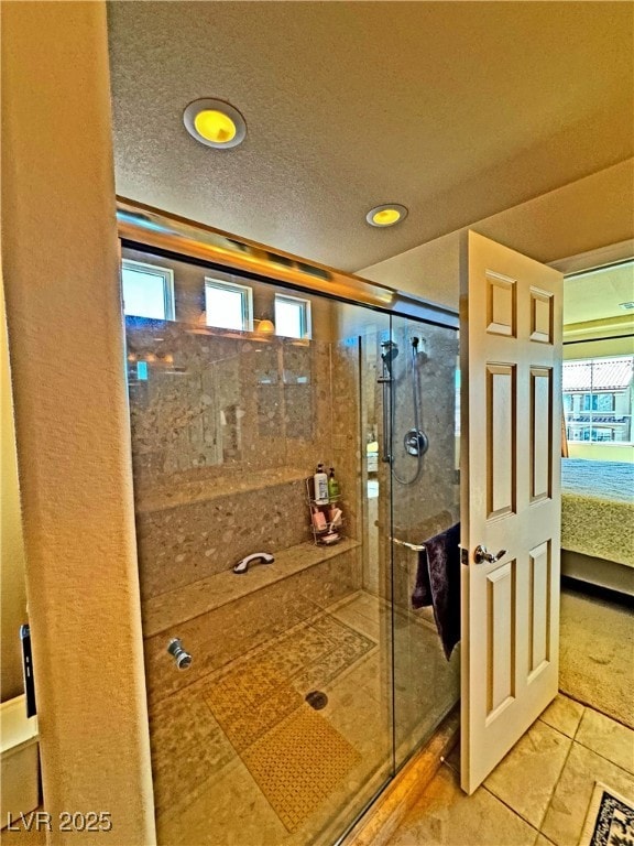 bathroom featuring an enclosed shower and a textured ceiling