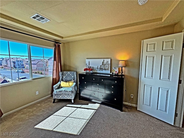 sitting room with carpet flooring and a tray ceiling