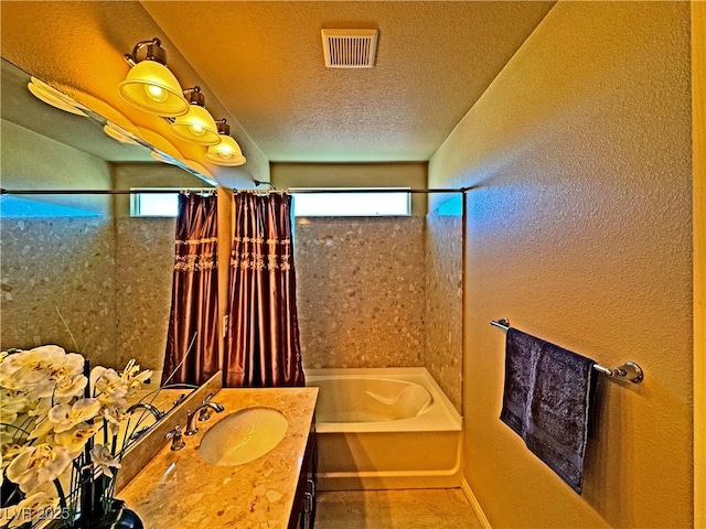 bathroom with vanity, shower / tub combo, and a textured ceiling