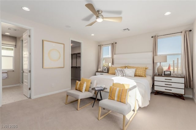 bedroom with ensuite bath, ceiling fan, light carpet, a spacious closet, and a closet