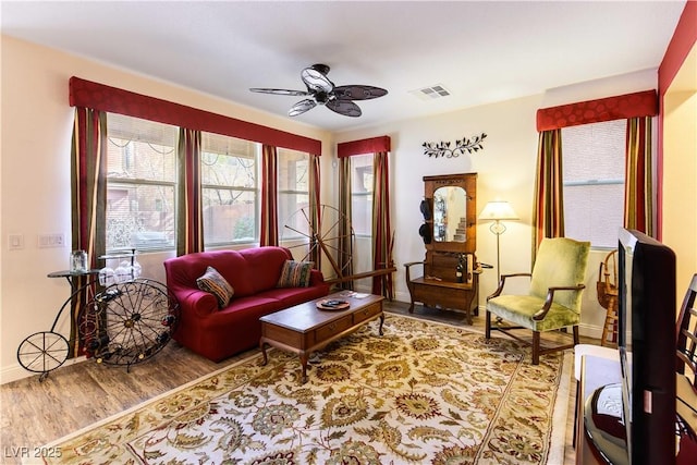 living area featuring hardwood / wood-style floors and ceiling fan