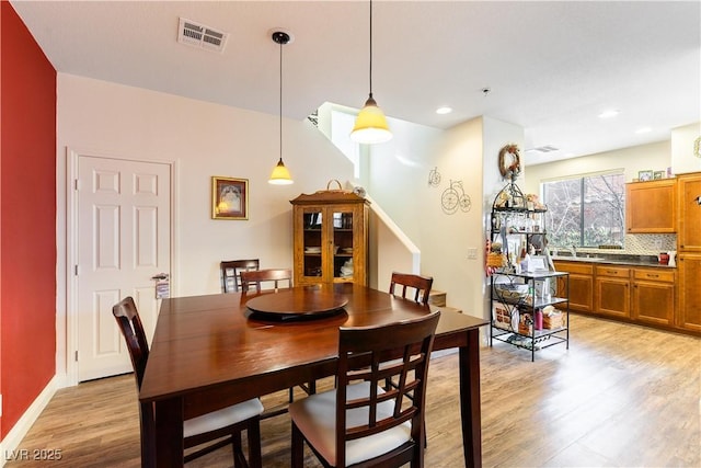 dining area featuring sink and light hardwood / wood-style floors