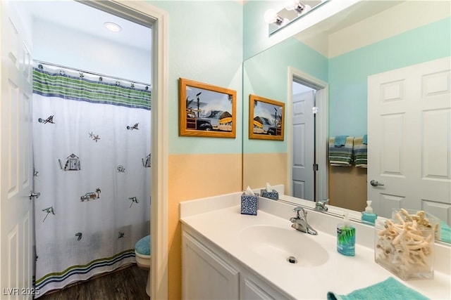 bathroom with hardwood / wood-style flooring, vanity, and walk in shower