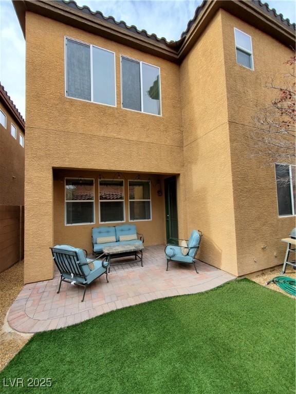 back of house featuring a patio, outdoor lounge area, and a yard