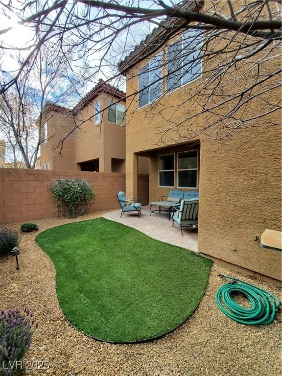 rear view of property featuring an outdoor living space and a patio area