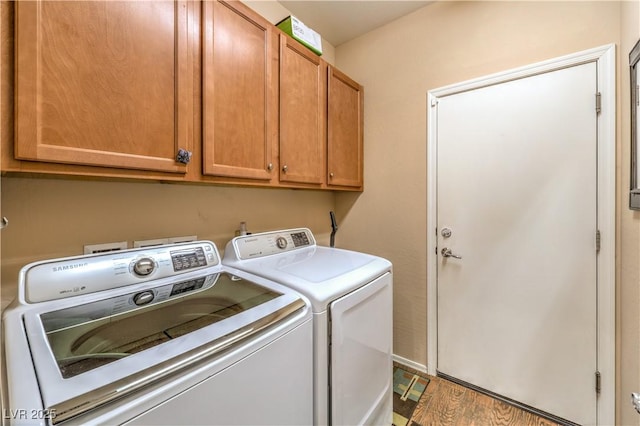 laundry area featuring cabinets, hardwood / wood-style floors, and independent washer and dryer