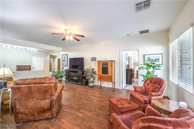 living room featuring ceiling fan, hardwood / wood-style floors, and a fireplace