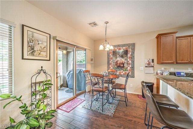 dining room featuring dark wood-type flooring and a notable chandelier