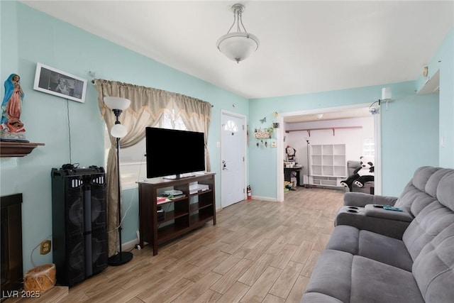 living area with baseboards and wood finished floors