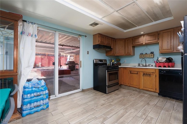 kitchen featuring under cabinet range hood, a sink, visible vents, stainless steel range with gas cooktop, and dishwasher