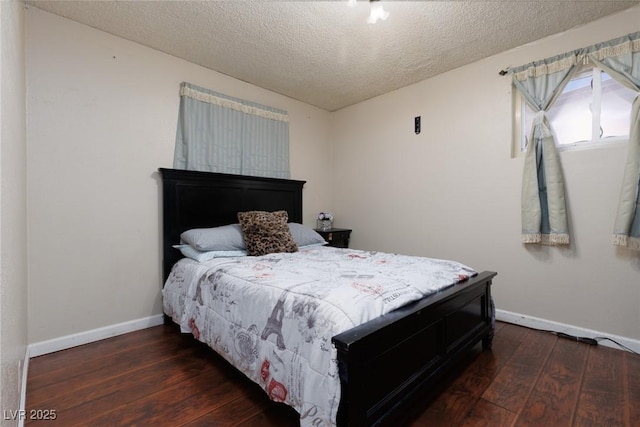 bedroom with a textured ceiling, wood-type flooring, and baseboards