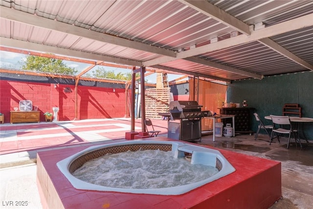 view of patio with a lanai, area for grilling, fence, and a hot tub