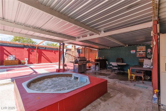 view of patio featuring outdoor dining area, an outdoor hot tub, fence, and grilling area