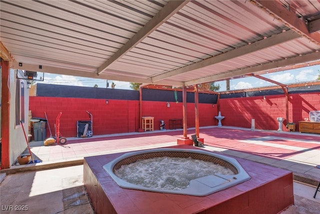 view of patio / terrace featuring fence and a hot tub