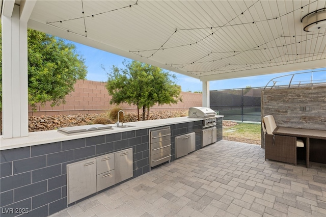 view of patio / terrace featuring exterior kitchen, a grill, and sink