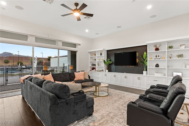 living room with dark wood-type flooring and ceiling fan