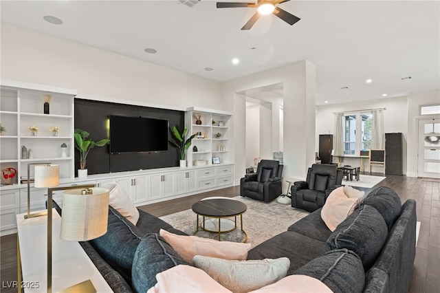 living room with dark hardwood / wood-style flooring and ceiling fan