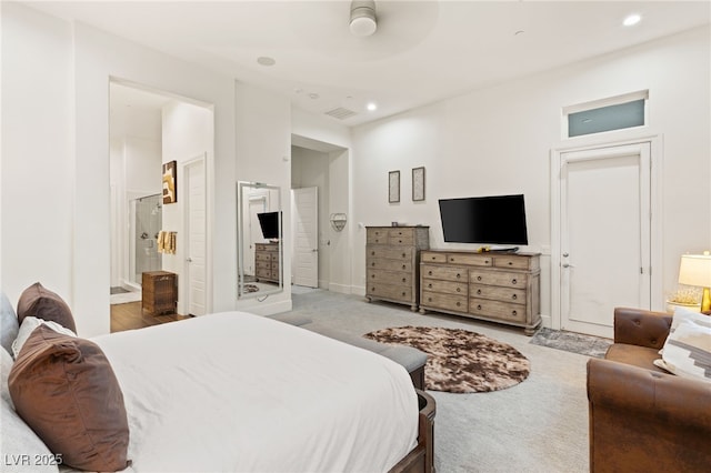 bedroom featuring connected bathroom and light colored carpet