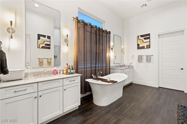 bathroom with hardwood / wood-style flooring, a bathing tub, and vanity