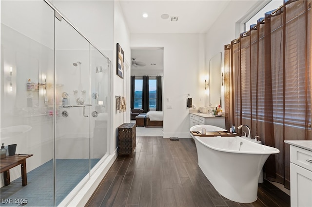 bathroom featuring vanity, plus walk in shower, and hardwood / wood-style floors