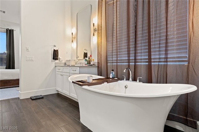 bathroom featuring hardwood / wood-style floors, vanity, and a bath