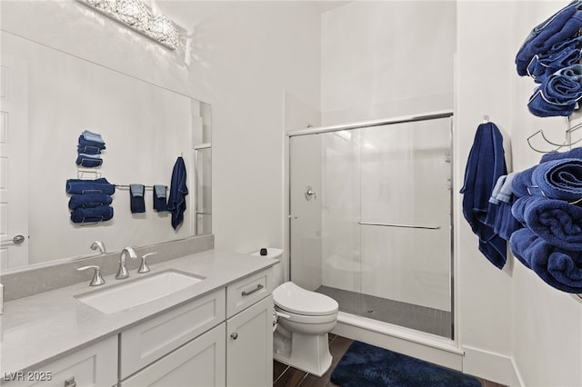 bathroom featuring vanity, toilet, and a shower with door