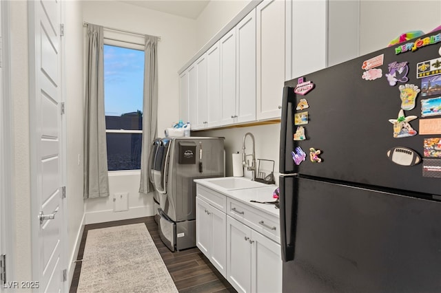 clothes washing area with cabinets, independent washer and dryer, and sink