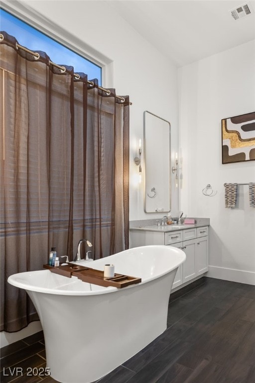 bathroom featuring hardwood / wood-style flooring, vanity, and a bathing tub