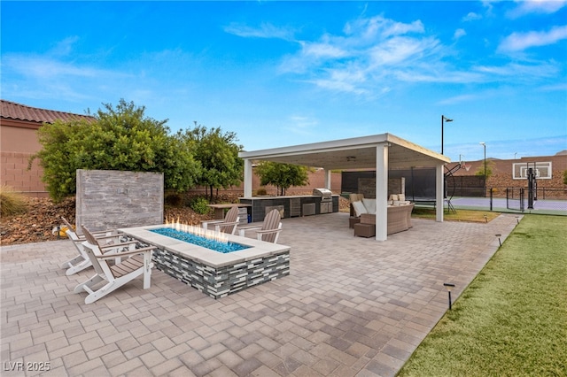 view of patio / terrace with an outdoor kitchen, area for grilling, and an outdoor living space with a fire pit