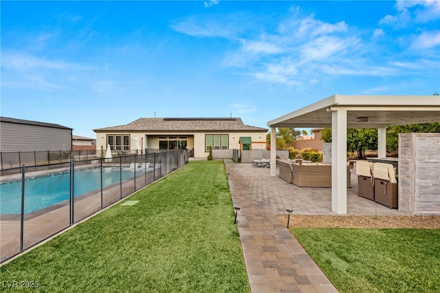 view of yard with an outdoor kitchen, an outdoor living space, a fenced in pool, and a patio area