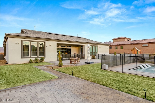 back of house featuring a patio area and a lawn