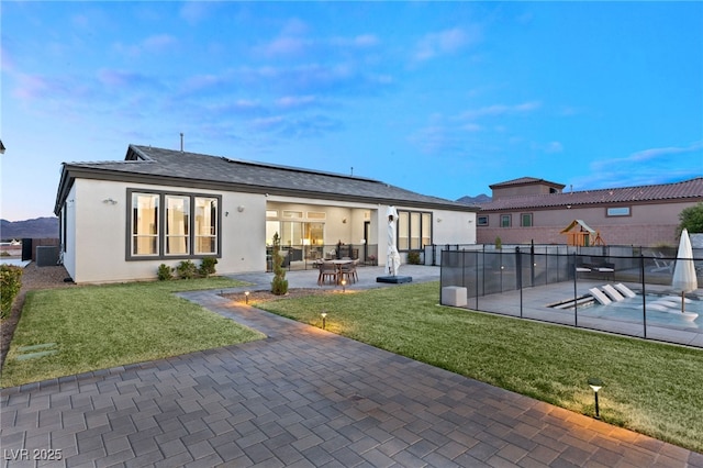 back of house with cooling unit, a lawn, and a patio