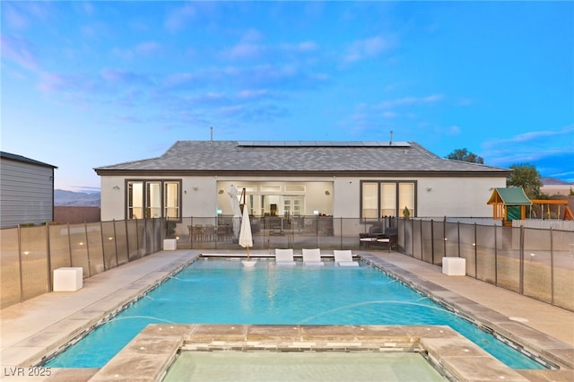 view of pool with a playground, a patio, pool water feature, and a jacuzzi