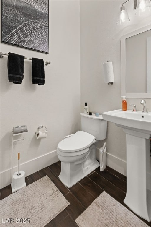 bathroom with hardwood / wood-style flooring and toilet