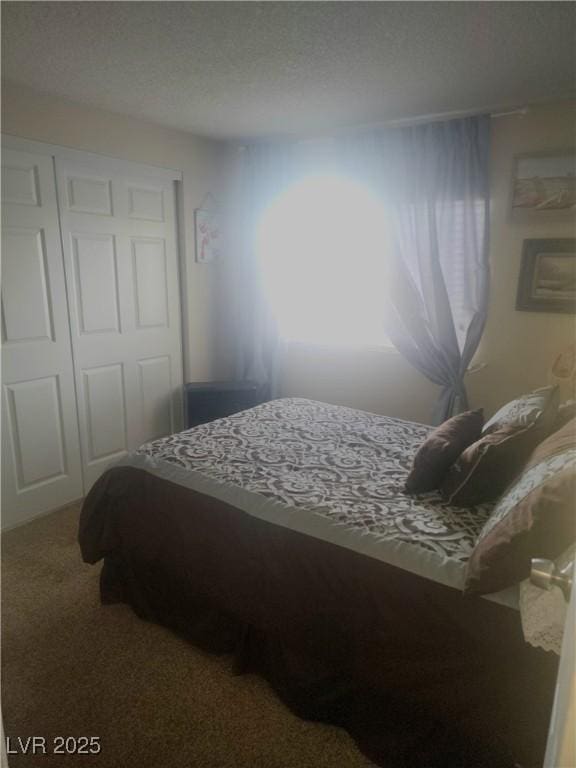 carpeted bedroom featuring a closet and a textured ceiling